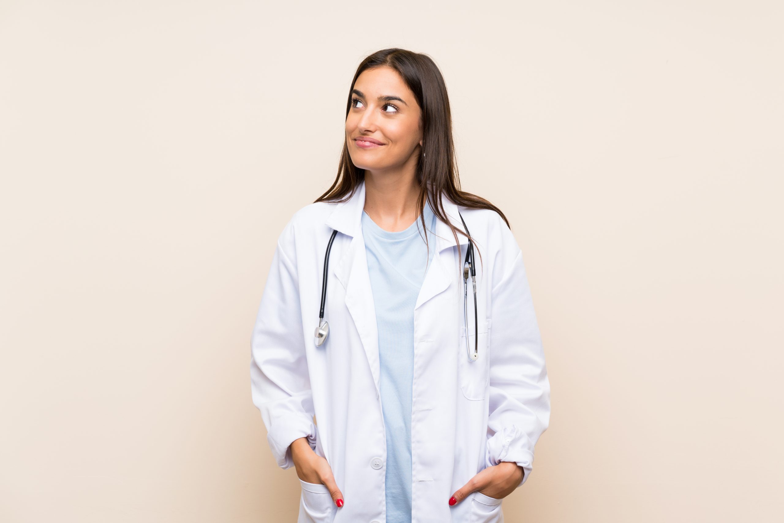 Young doctor woman over isolated background standing and looking to the side